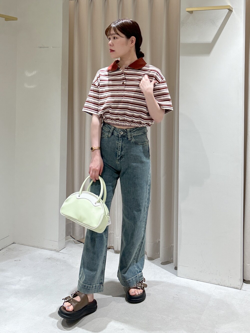 レッド系のポロシャツ、ブラック系のキャミソール、グリーン系のトートバッグを着用したレディースの春コーディネートの7枚目の写真