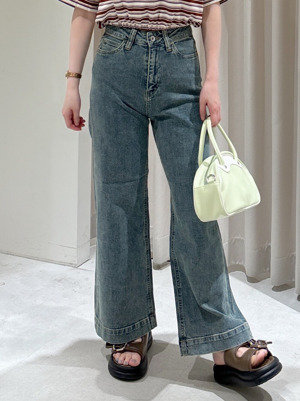 レッド系のポロシャツ、ブラック系のキャミソール、グリーン系のトートバッグを着用したレディースの春コーディネートの4枚目の写真