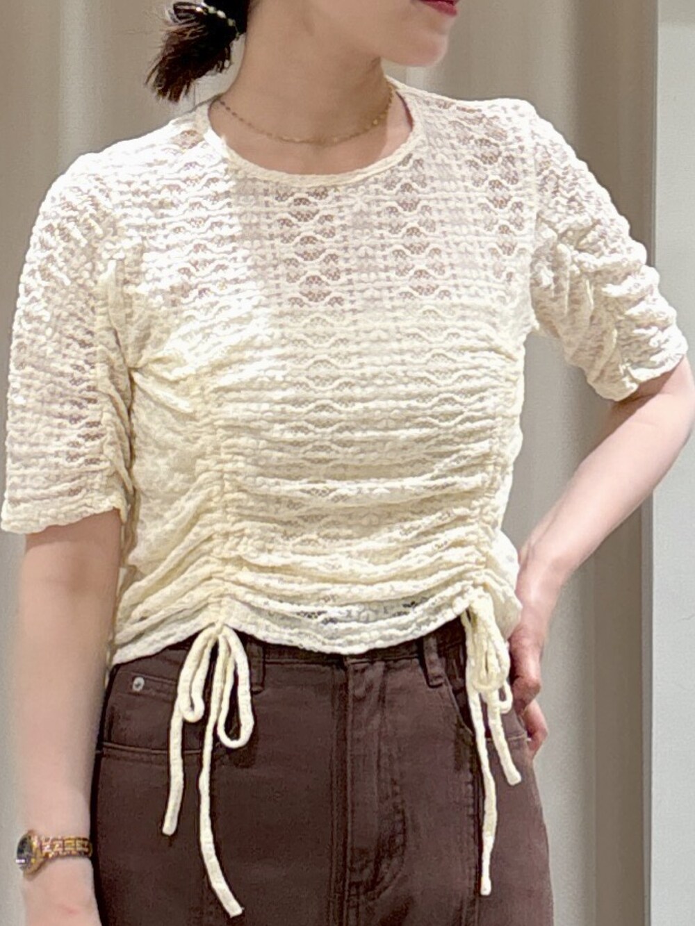 ホワイト系のTシャツ/カットソー、ホワイト系のキャミソール、ブラウン系のデニムパンツを着用したレディースの夏コーディネートの2枚目の写真