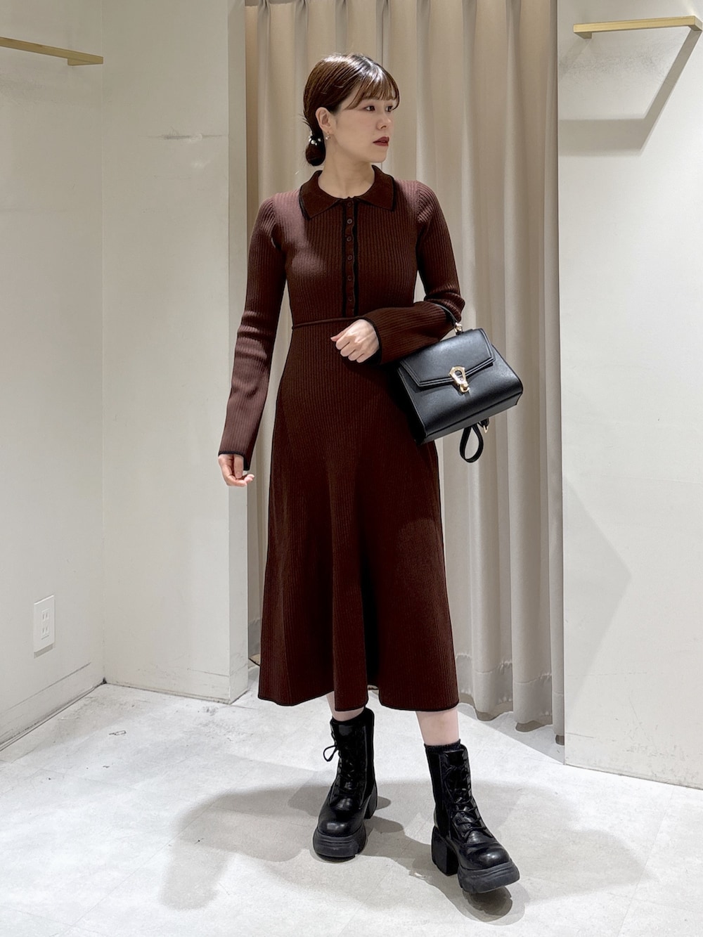 ブラウン系のワンピース、ブラック系のトートバッグ、ブラック系のブーツを着用したレディースの秋コーディネートの2枚目の写真