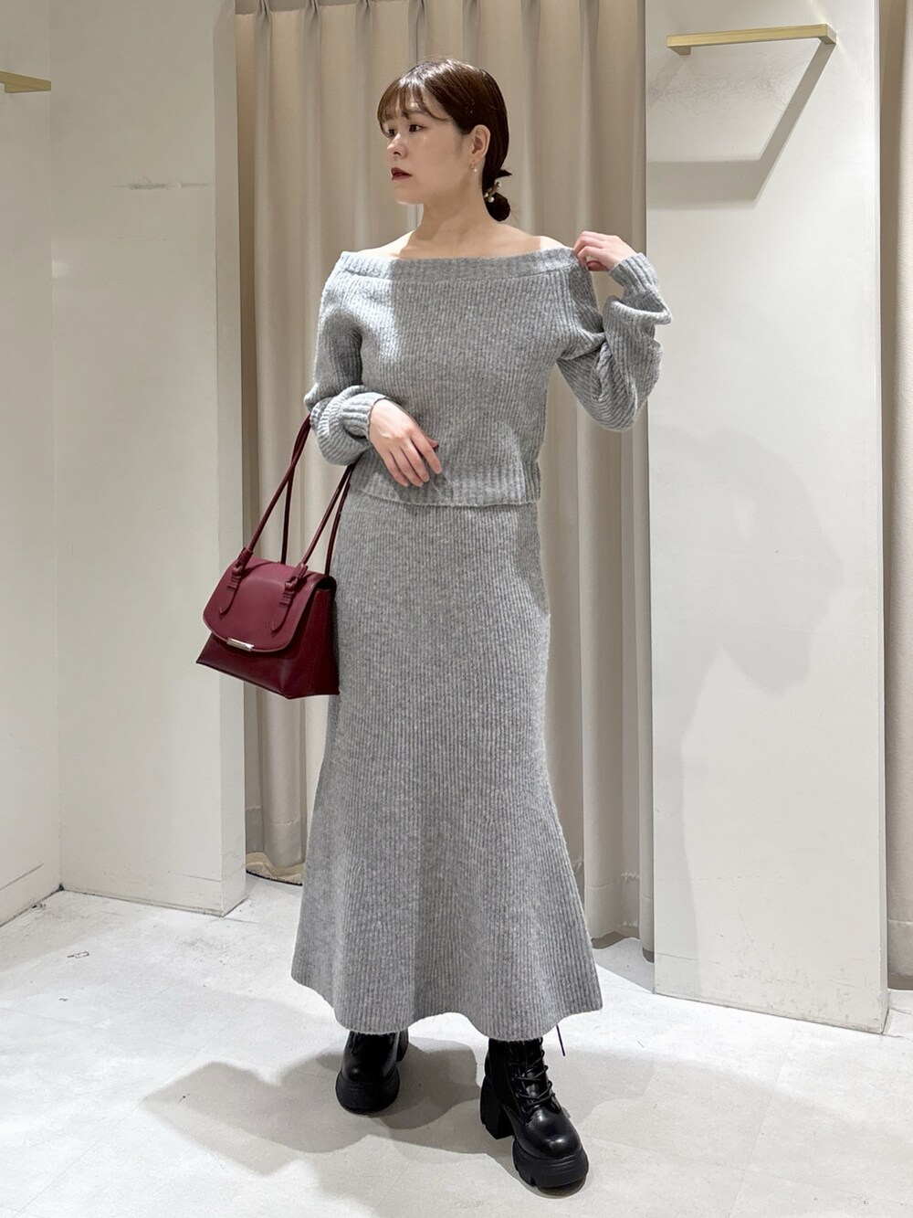 ブルー系のピーコート、レッド系のショルダーバッグ、グレー系のワンピースを着用したレディースの秋コーディネートの6枚目の写真