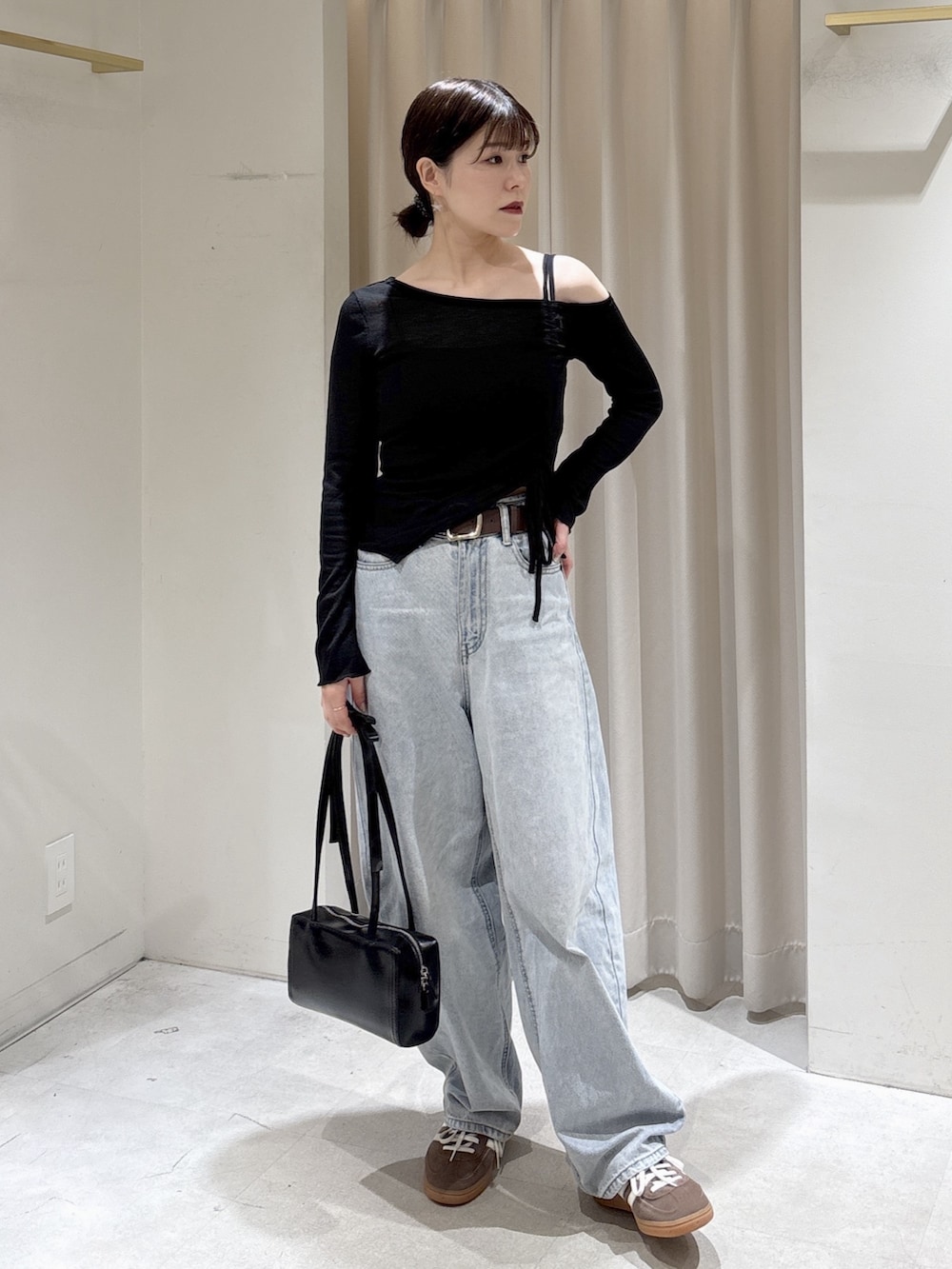 ブラック系のTシャツ/カットソー、ブルー系のデニムパンツ、ブラック系のショルダーバッグを着用したレディースの春コーディネートの7枚目の写真