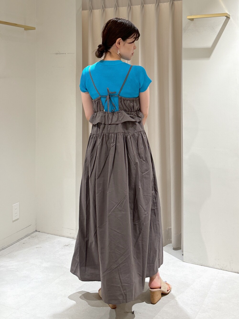 グレー系のワンピース、ブルー系のニット/セーター、ブラウン系のショルダーバッグを着用したレディースの夏コーディネートの3枚目の写真