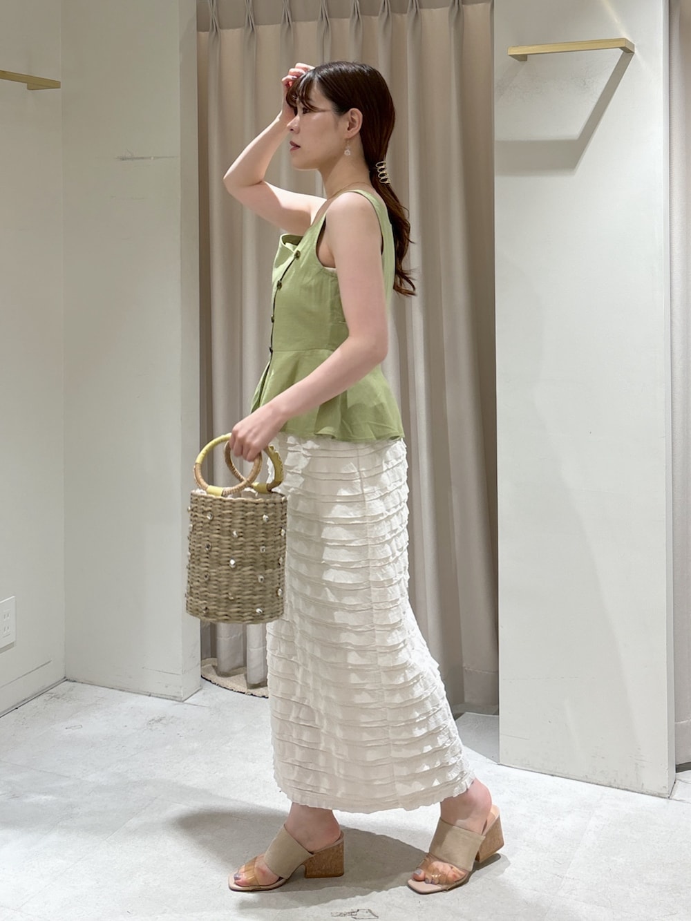 グリーン系のシャツ/ブラウス、ホワイト系のスカート、イエロー系のかごバッグを着用したレディースの夏コーディネートの3枚目の写真