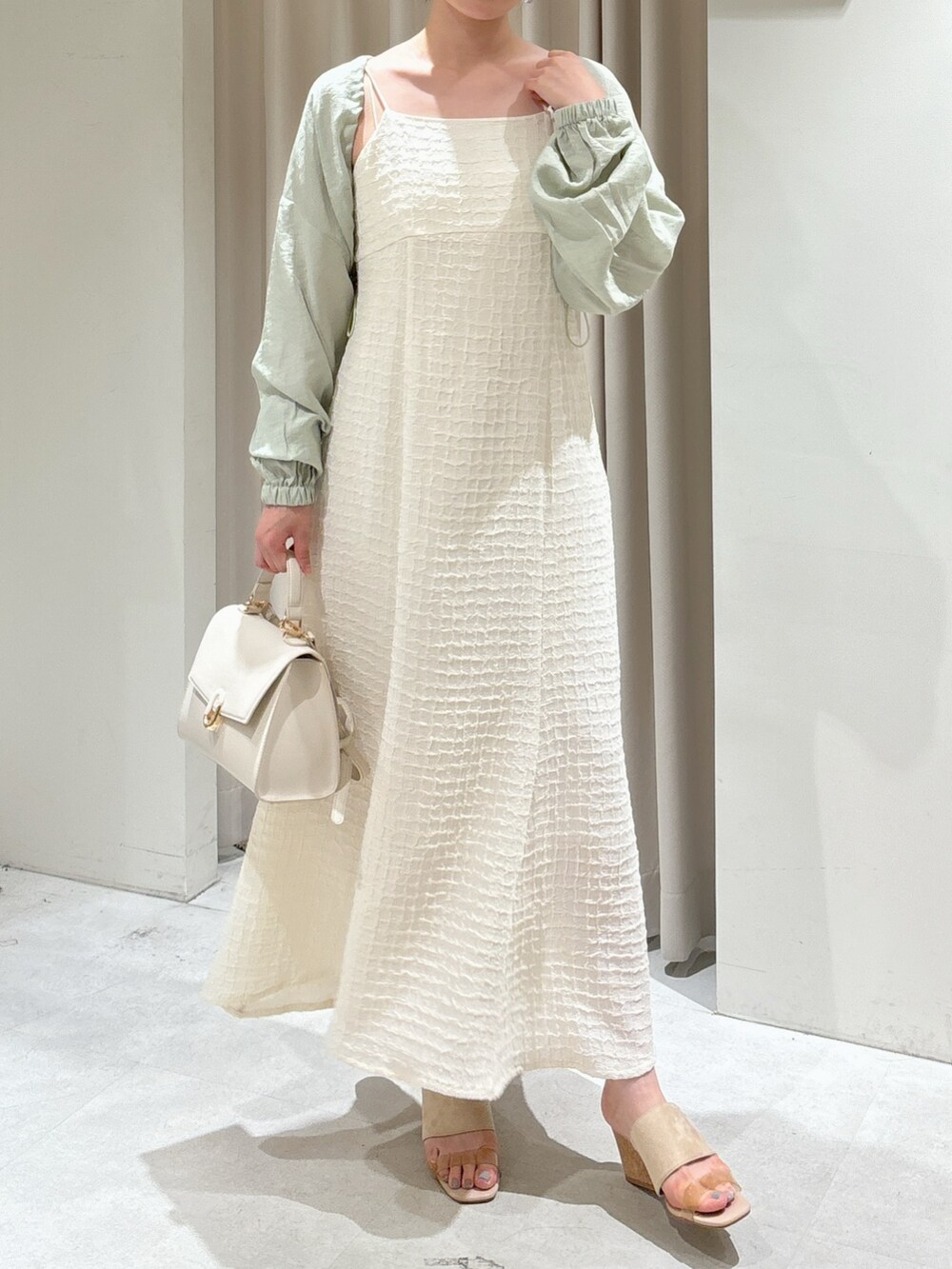 ホワイト系のワンピース、グリーン系のカーディガン/ボレロ、ホワイト系のショルダーバッグを着用したレディースの夏コーディネートの2枚目の写真