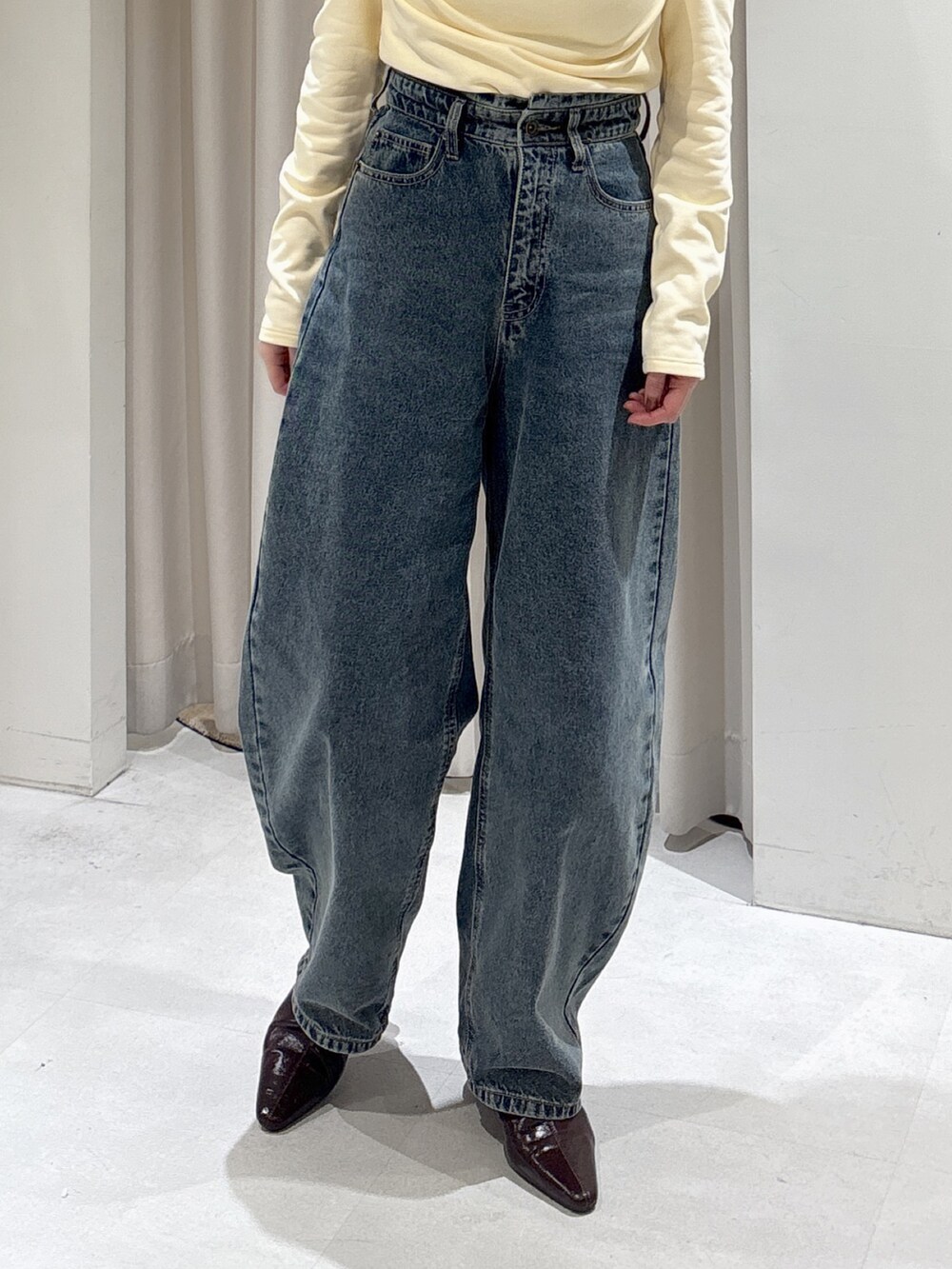 イエロー系のTシャツ/カットソー、ブルー系のデニムパンツ、ブラウン系のパンプスを着用したレディースの冬コーディネートの3枚目の写真