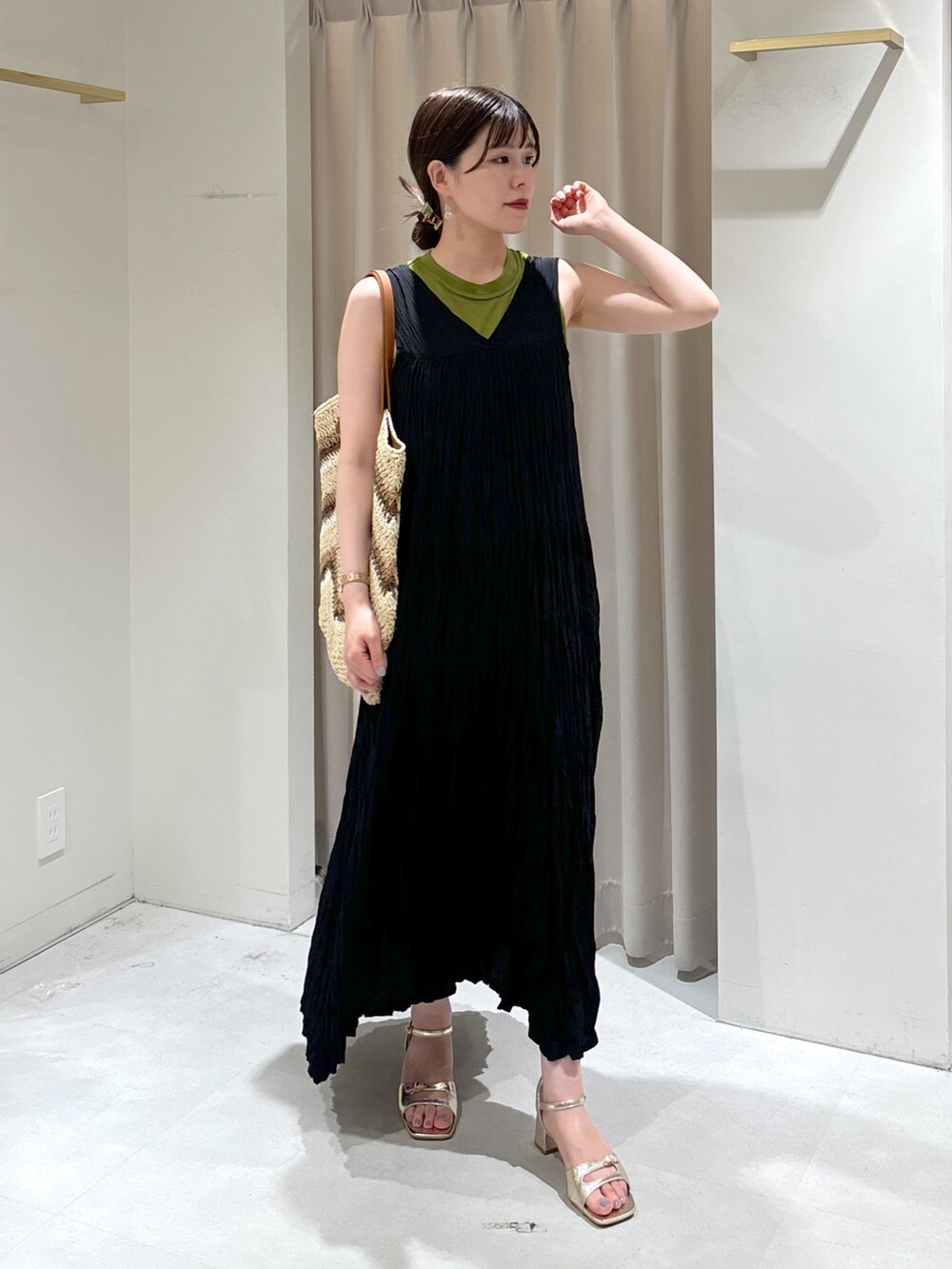 ブラック系のワンピース、ベージュ系のトートバッグ、ゴールド系のサンダルを着用したレディースの夏コーディネートの10枚目の写真