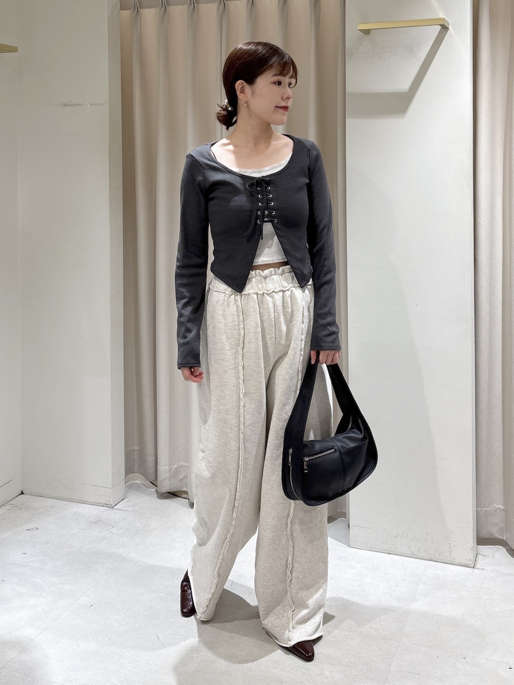 ブラック系のTシャツ/カットソー、ホワイト系のスウェットパンツ、ブラック系のハンドバッグを着用したレディースの秋コーディネートの2枚目の写真