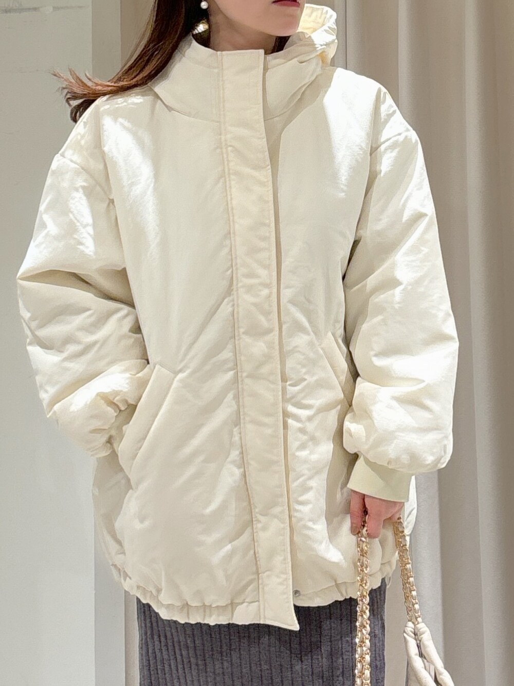 ホワイト系のブルゾン、グレー系のワンピース、ホワイト系のトートバッグを着用したレディースの冬コーディネートの6枚目の写真