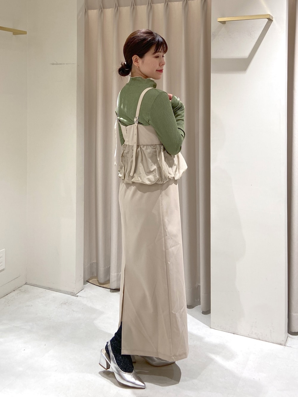 ホワイト系のワンピース、ブラック系のショルダーバッグ、グリーン系のTシャツ/カットソーを着用したレディースの冬コーディネートの3枚目の写真