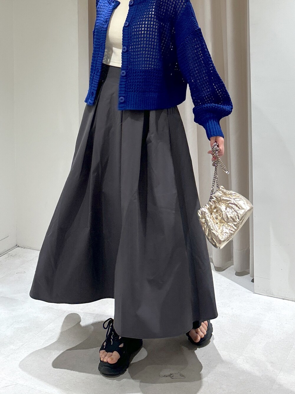 ブルー系のカーディガン/ボレロ、ホワイト系のタンクトップ、グレー系のスカートを着用したレディースの春コーディネートの5枚目の写真