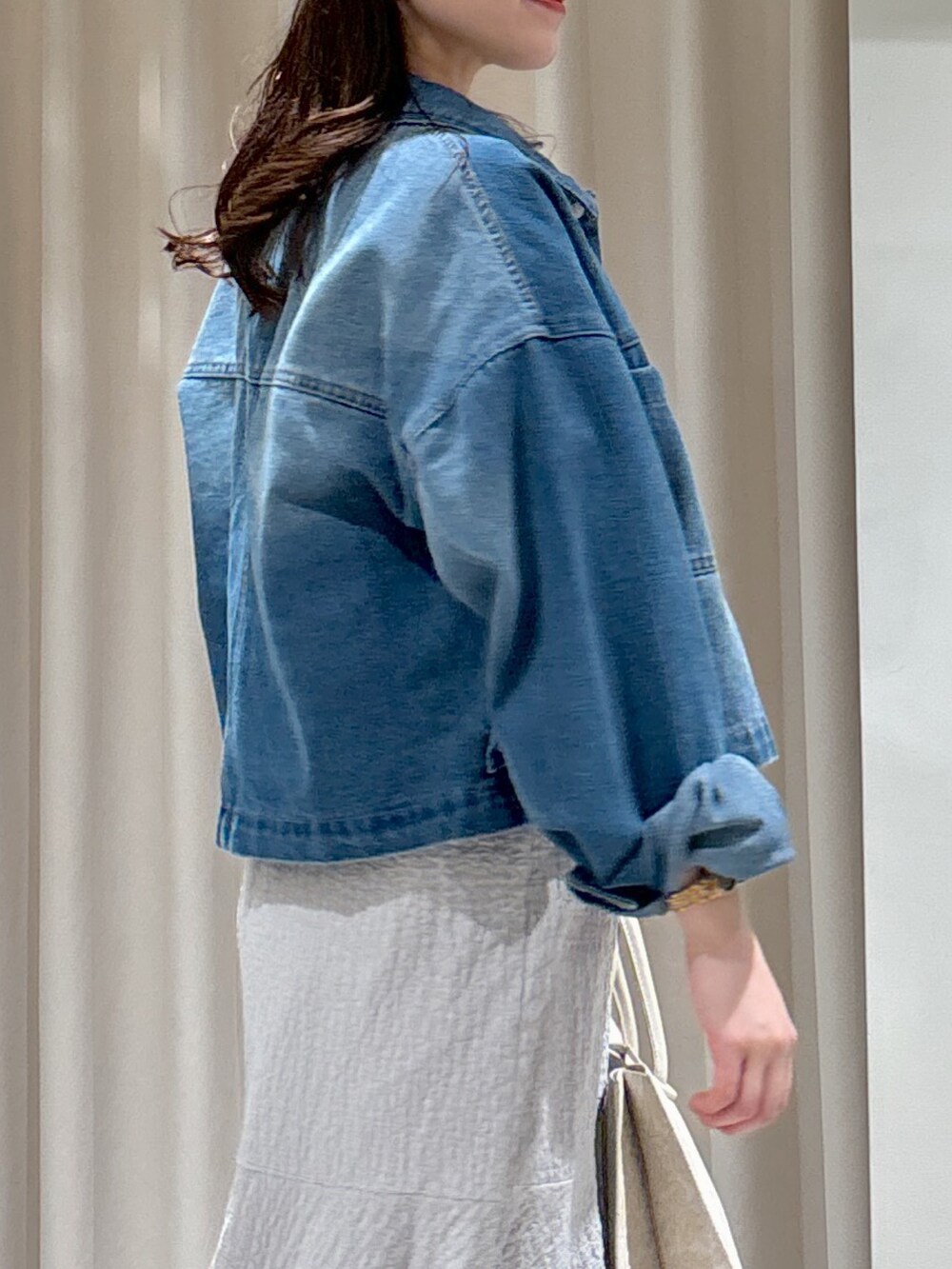 ブルー系のブルゾン、グレー系のワンピース、ホワイト系のトートバッグを着用したレディースの春コーディネートの5枚目の写真