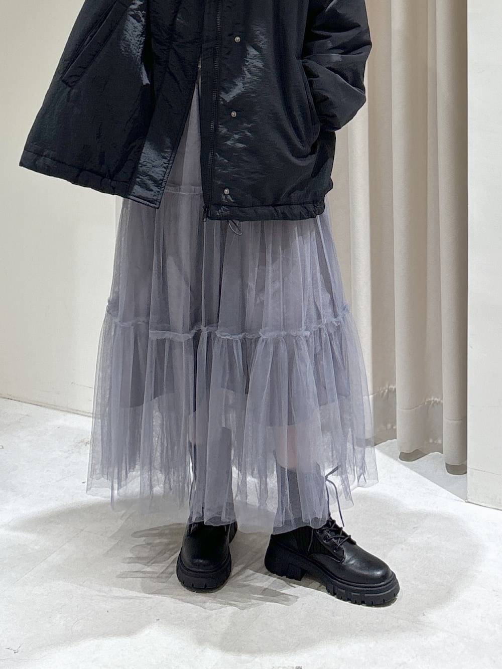 ブラック系のダウンジャケット/コート、グレー系のスカート、ブラック系のブーツを着用したレディースの秋コーディネートの7枚目の写真