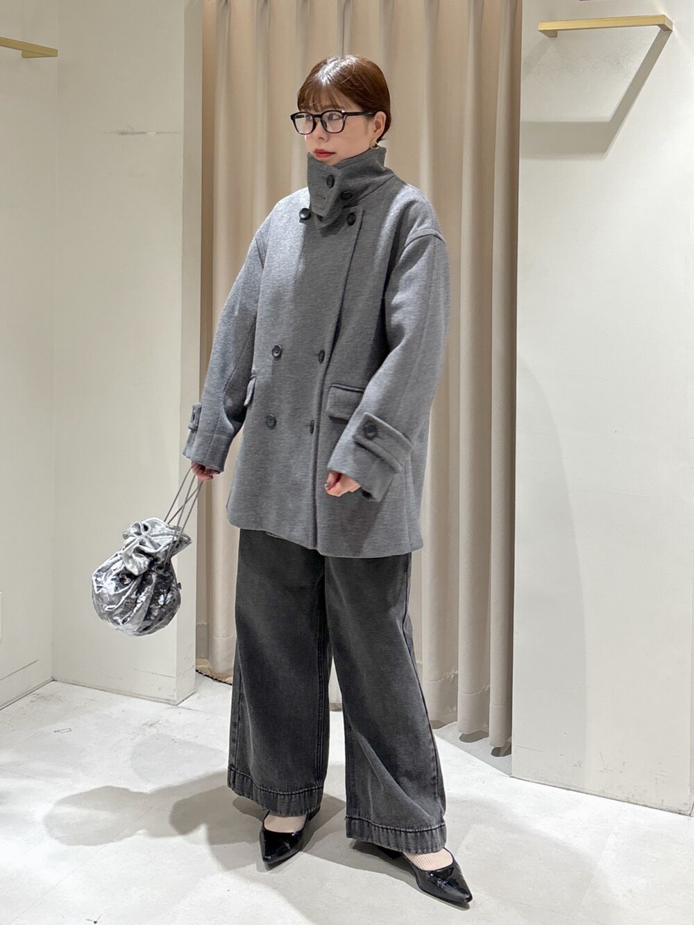 ピンク系のニット/セーター、ブラック系のデニムパンツ、グレー系のハンドバッグを着用したレディースの秋コーディネートの8枚目の写真