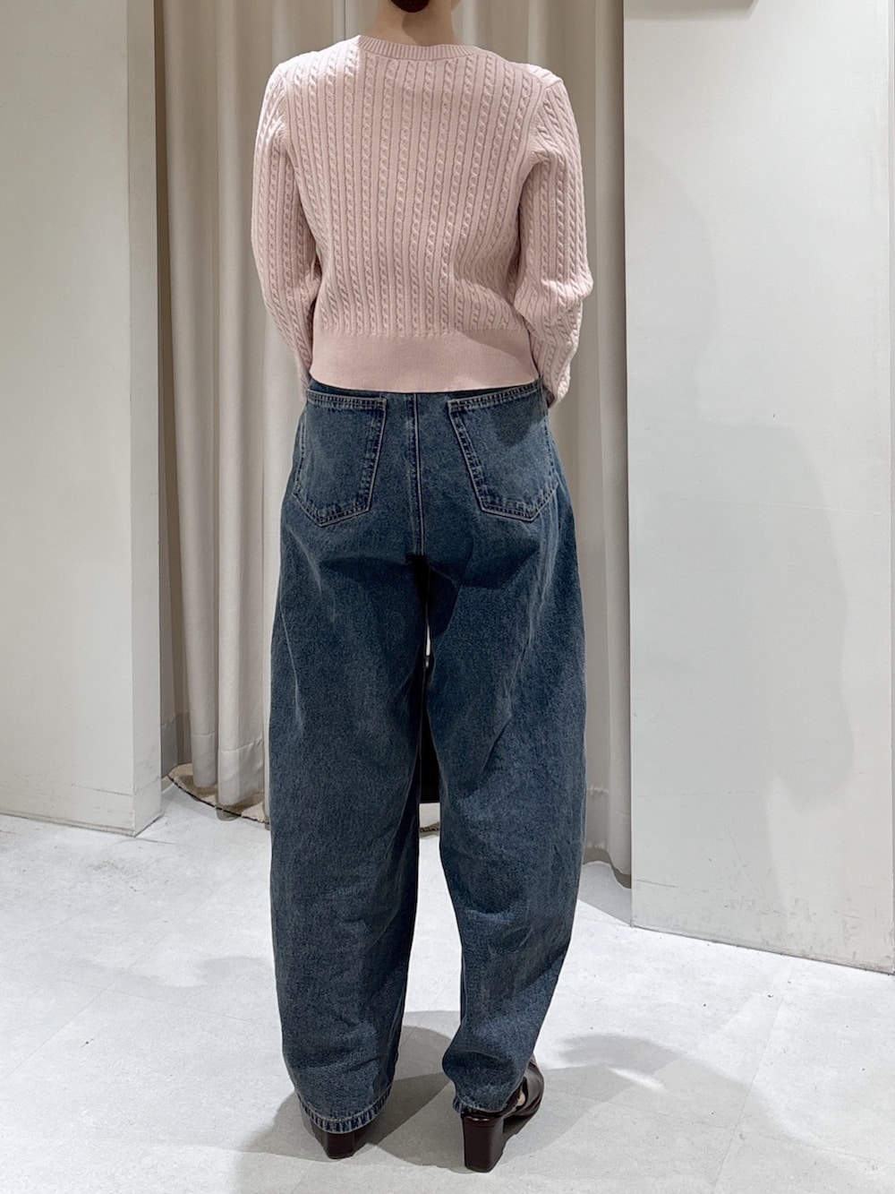 ピンク系のニット/セーター、ブラック系のショルダーバッグ、ブルー系のデニムパンツを着用したレディースの冬コーディネートの4枚目の写真