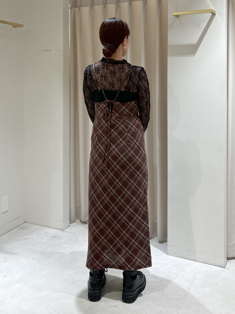 ブラウン系のワンピース、ホワイト系のカーディガン/ボレロ、ブラック系のTシャツ/カットソーを着用したレディースの冬コーディネートの6枚目の写真