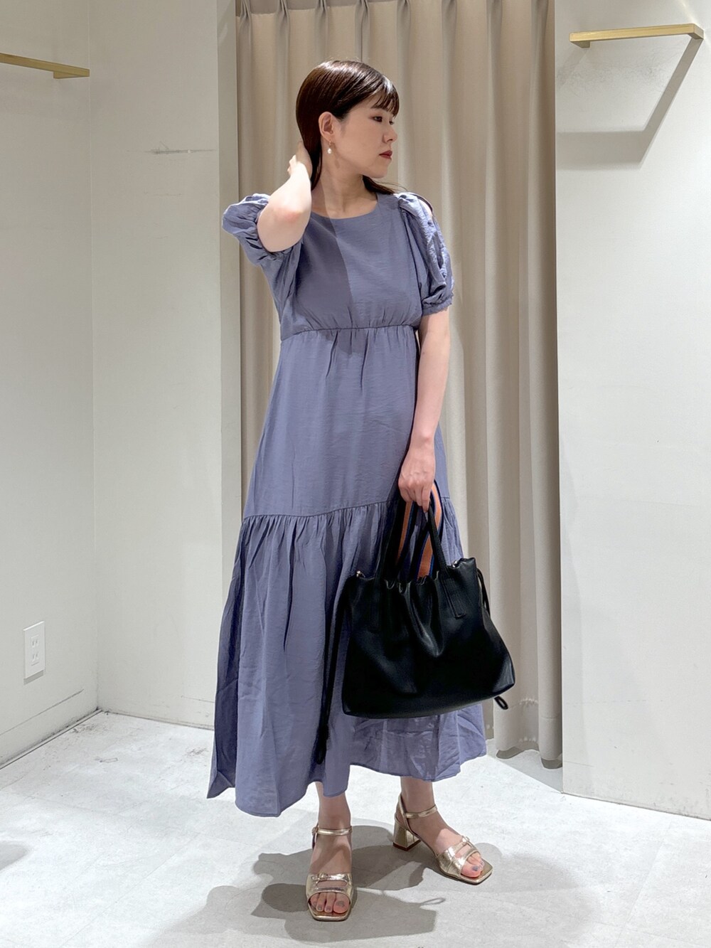 ブルー系のワンピース、ブラック系のハンドバッグ、ゴールド系のサンダルを着用したレディースの夏コーディネートの4枚目の写真