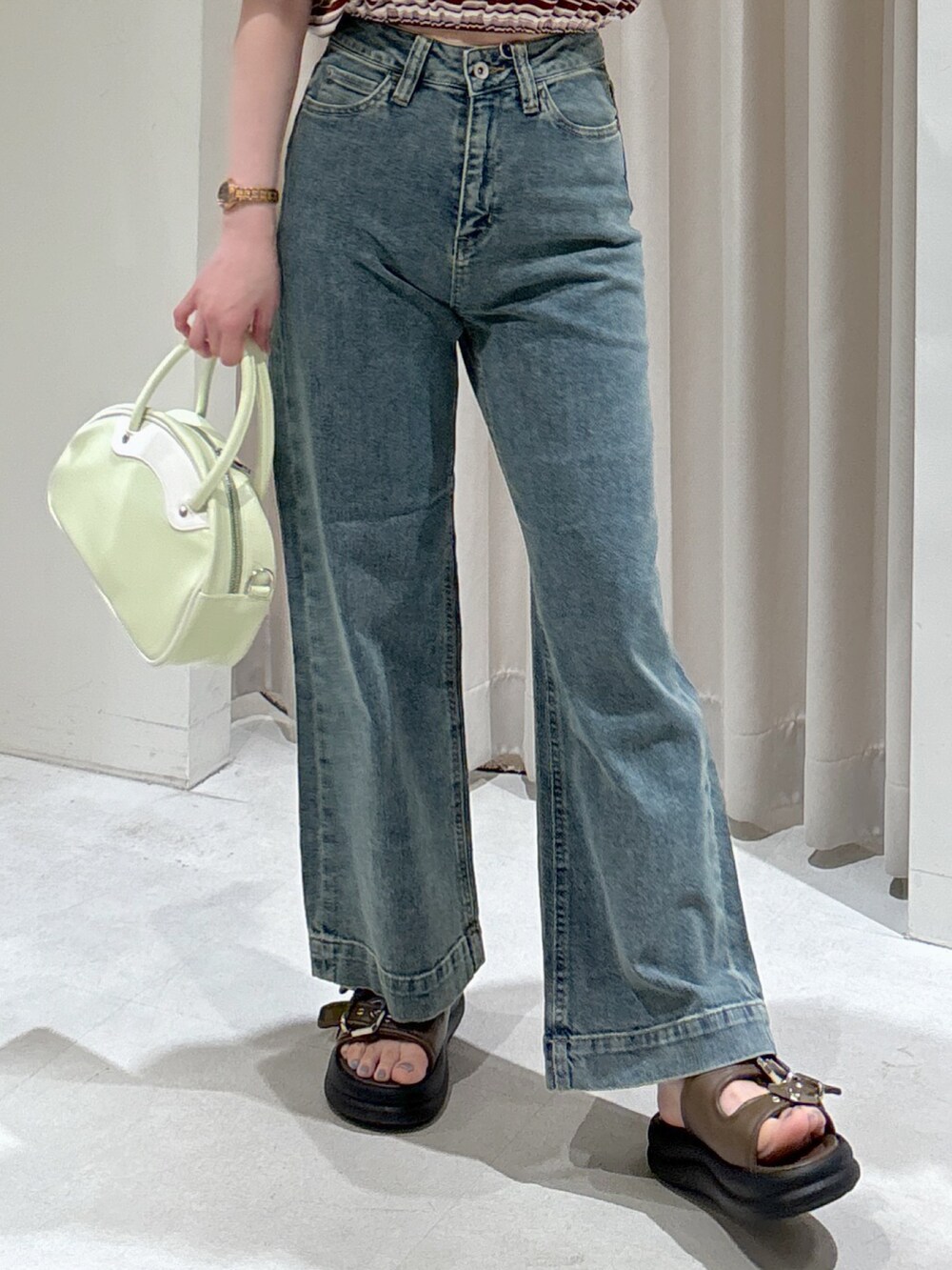 レッド系のポロシャツ、ブラック系のキャミソール、グリーン系のトートバッグを着用したレディースの春コーディネートの6枚目の写真