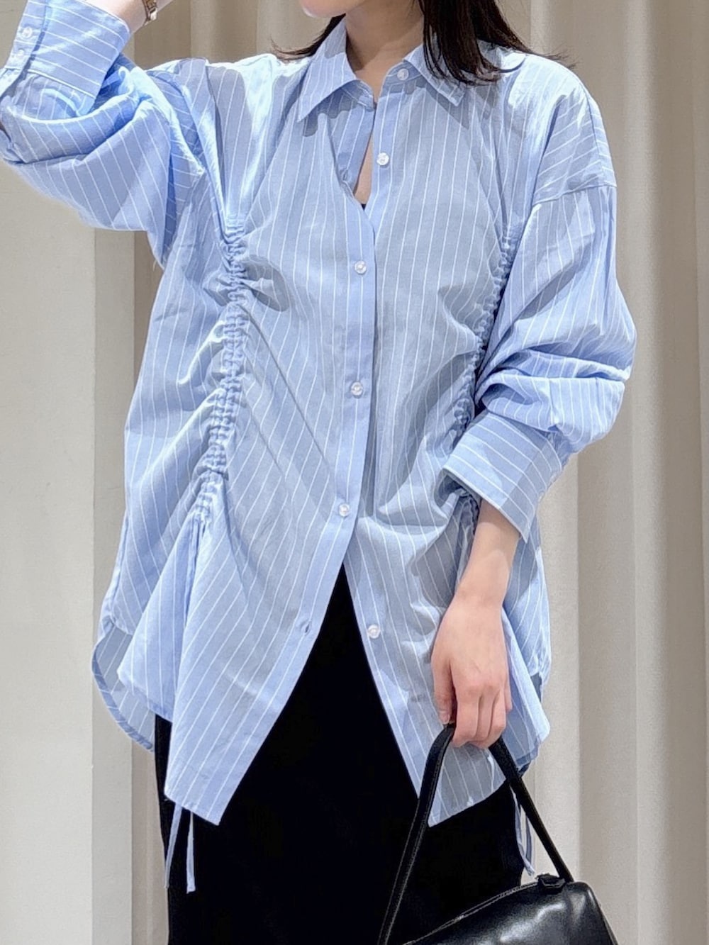 ブルー系のシャツ/ブラウス、ブラック系のハンドバッグ、ブラック系のスカートを着用したレディースの春コーディネートの5枚目の写真