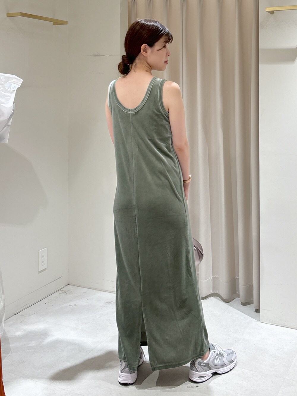 グリーン系のワンピース、シルバー系のハンドバッグ、グレー系のスニーカーを着用したレディースの秋コーディネートの4枚目の写真