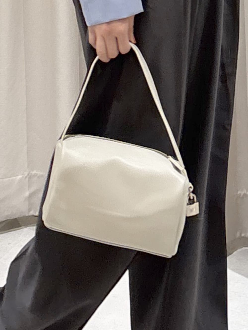 ブルー系のシャツ/ブラウス、グレー系のスラックス、ホワイト系のハンドバッグを着用したレディースの冬コーディネートの5枚目の写真