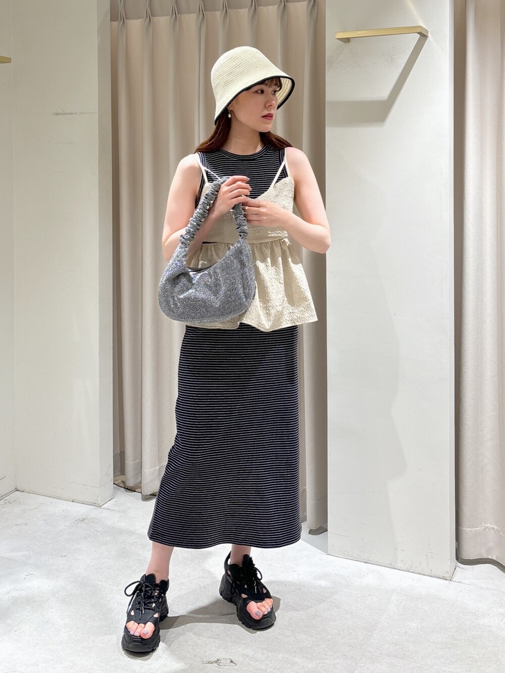 ホワイト系のシャツ/ブラウス、ブラック系のサンダル、シルバー系のハンドバッグを着用したレディースの春コーディネートの2枚目の写真