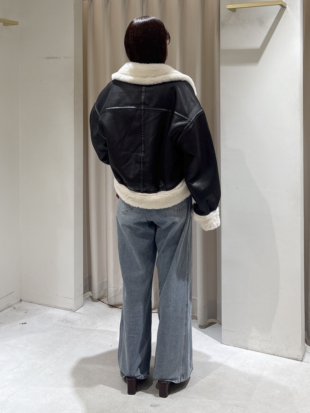 ブラック系のブルゾン、ブルー系のニット/セーター、レッド系のショルダーバッグを着用したレディースの秋コーディネートの3枚目の写真