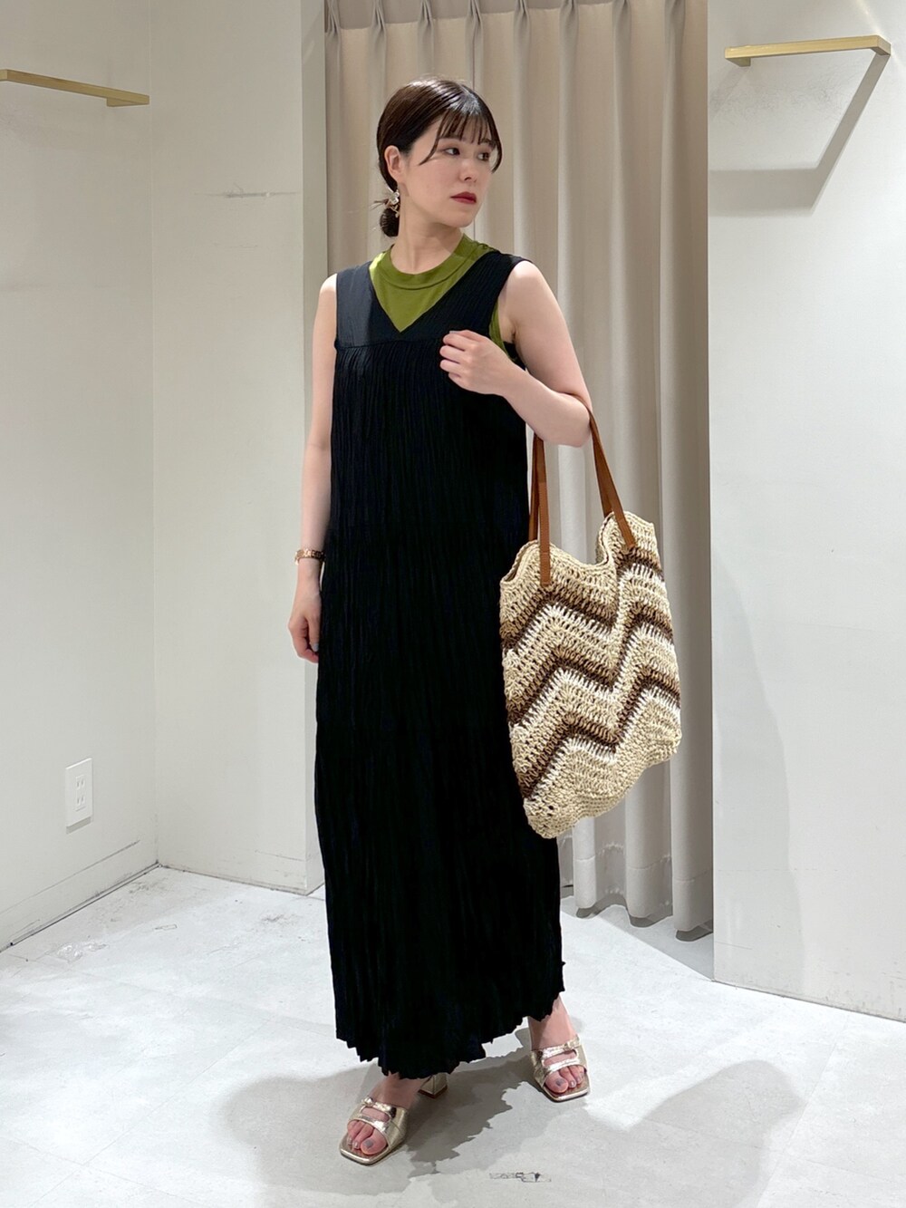 ブラック系のワンピース、ベージュ系のトートバッグ、ゴールド系のサンダルを着用したレディースの夏コーディネートの2枚目の写真