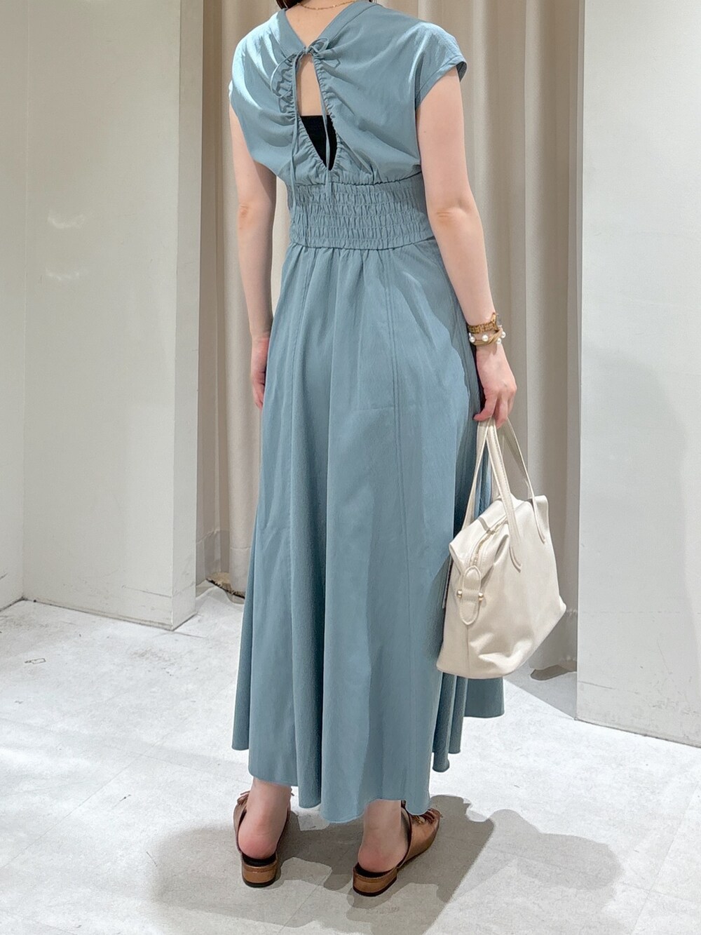 ブルー系のワンピース、ホワイト系のボストンバッグ、ブラウン系のサンダルを着用したレディースの夏コーディネートの3枚目の写真