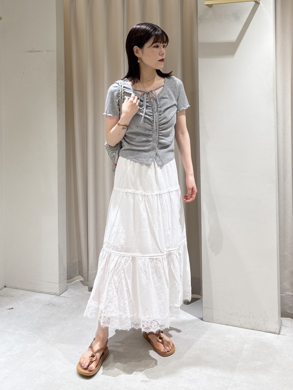 グレー系のTシャツ/カットソー、ホワイト系のスカート、ベージュ系のサンダルを着用したレディースの夏コーディネートの5枚目の写真