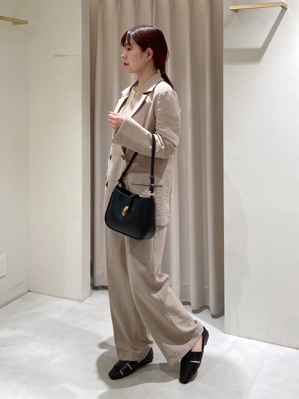 ベージュ系のテーラードジャケット、ホワイト系のスラックス、ホワイト系のカーディガン/ボレロを着用したレディースの春コーディネートの2枚目の写真