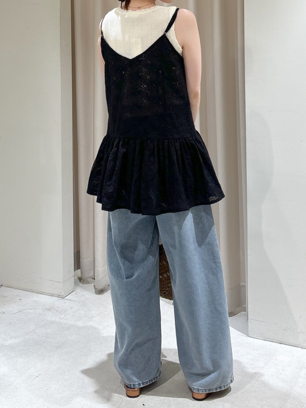 ブラック系のシャツ/ブラウス、ホワイト系のニット/セーター、ベージュ系のトートバッグを着用したレディースの春コーディネートの6枚目の写真