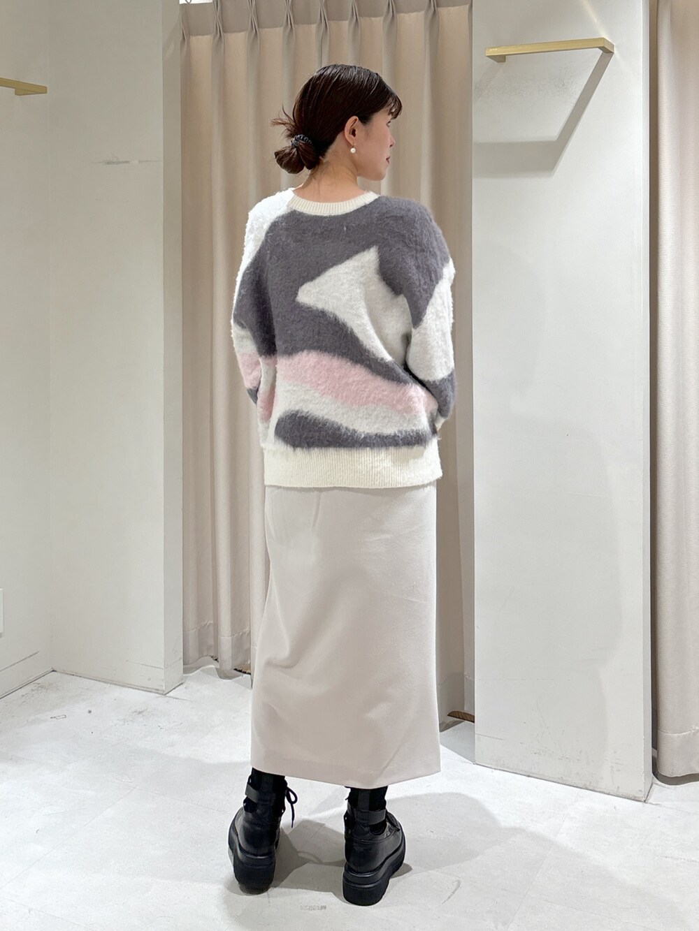 ホワイト系のニット/セーター、グレー系のスカート、シルバー系のハンドバッグを着用したレディースの冬コーディネートの4枚目の写真