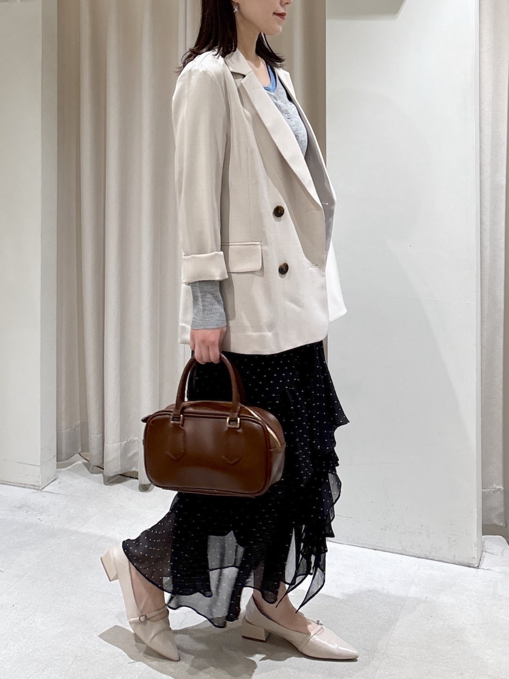 ベージュ系のブルゾン、グレー系のニット/セーター、ブラウン系のハンドバッグを着用したレディースの春コーディネートの4枚目の写真