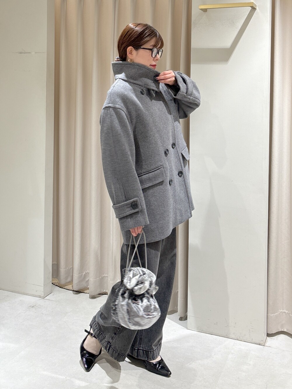 ピンク系のニット/セーター、ブラック系のデニムパンツ、グレー系のハンドバッグを着用したレディースの秋コーディネートの9枚目の写真