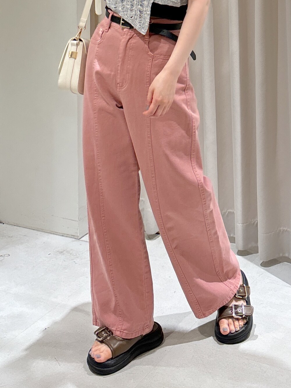 グレー系のニット/セーター、ブラック系のキャミソール、ピンク系のデニムパンツを着用したレディースの夏コーディネートの6枚目の写真