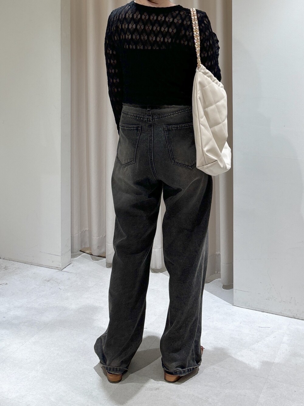 ブラック系のカーディガン/ボレロ、ブラック系のキャミソール、ホワイト系のトートバッグを着用したレディースの春コーディネートの3枚目の写真