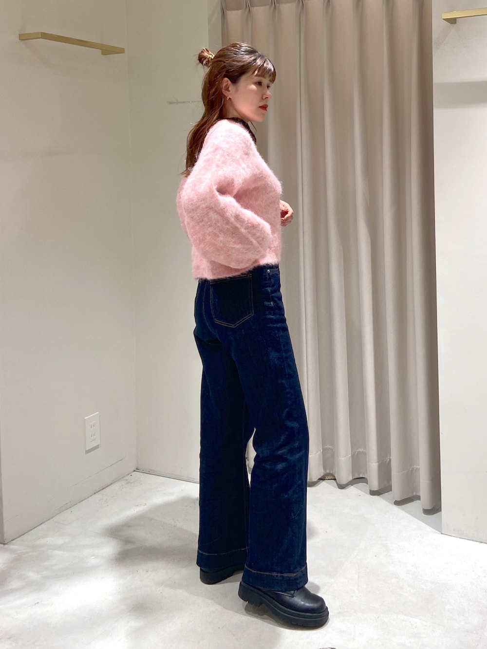 ピンク系のニット/セーター、ブラウン系のショルダーバッグ、ブルー系のデニムパンツを着用したレディースの冬コーディネートの2枚目の写真