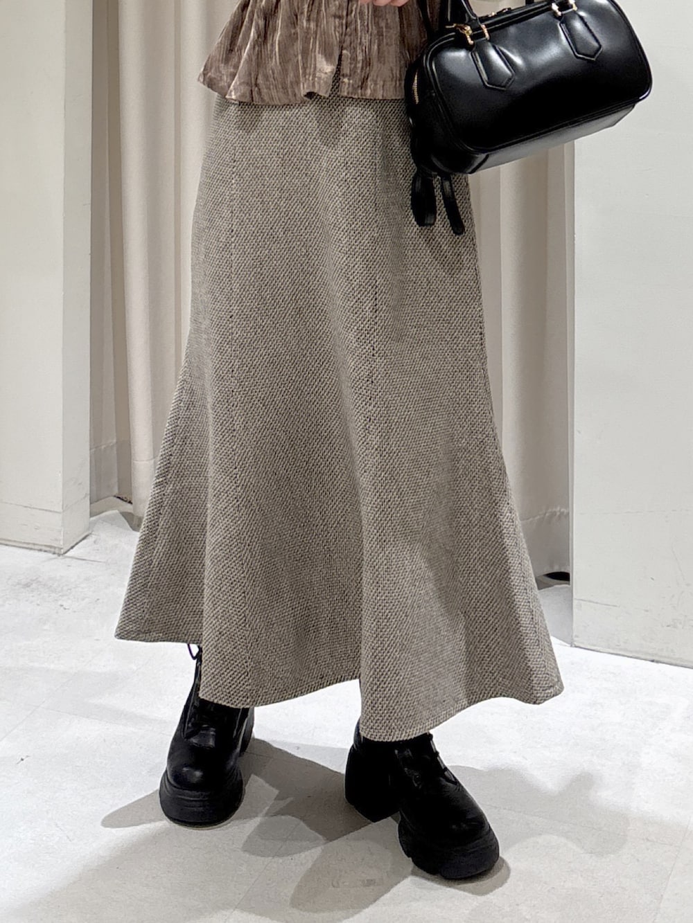 ベージュ系のシャツ/ブラウス、イエロー系のニット/セーター、ブラウン系のスカートを着用したレディースの冬コーディネートの4枚目の写真