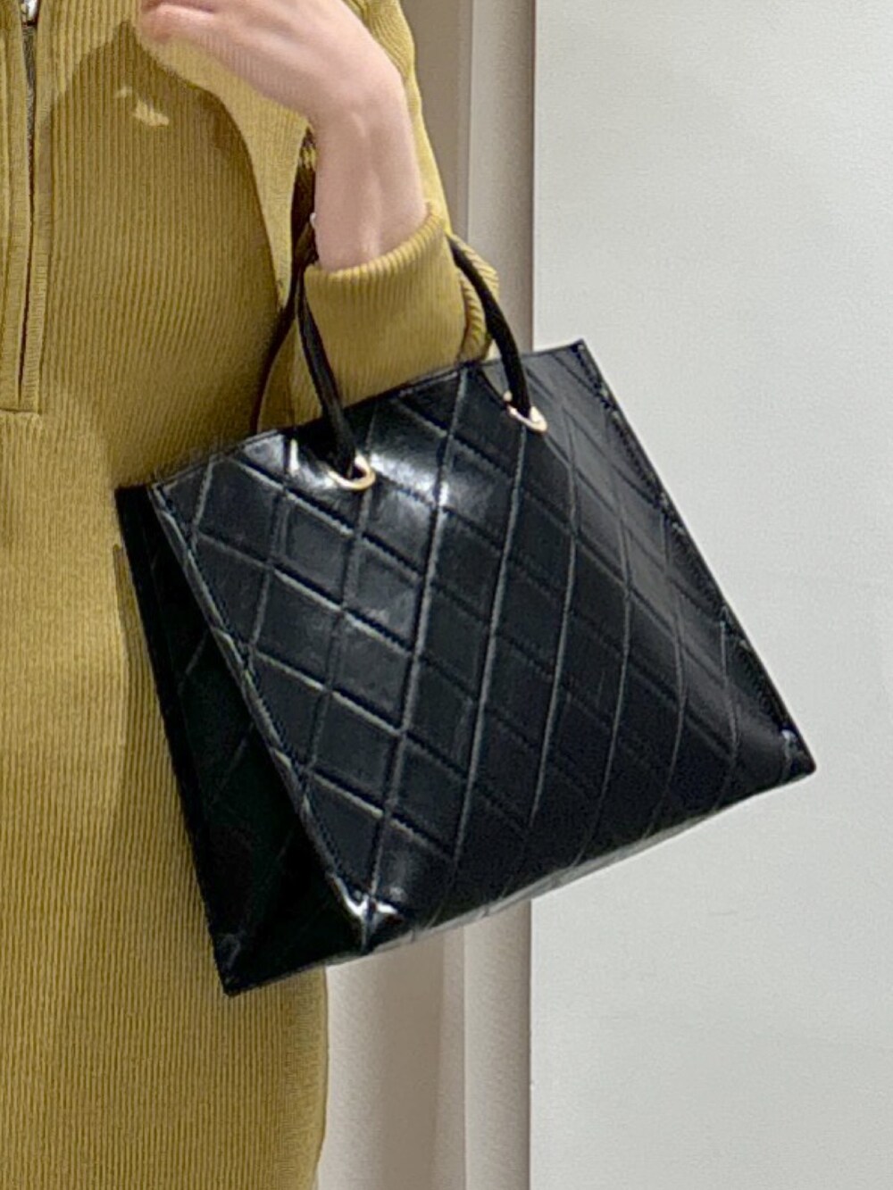 ブラック系のショルダーバッグ、ブラック系のパンプス、グリーン系のワンピースを着用したレディースの秋コーディネートの4枚目の写真