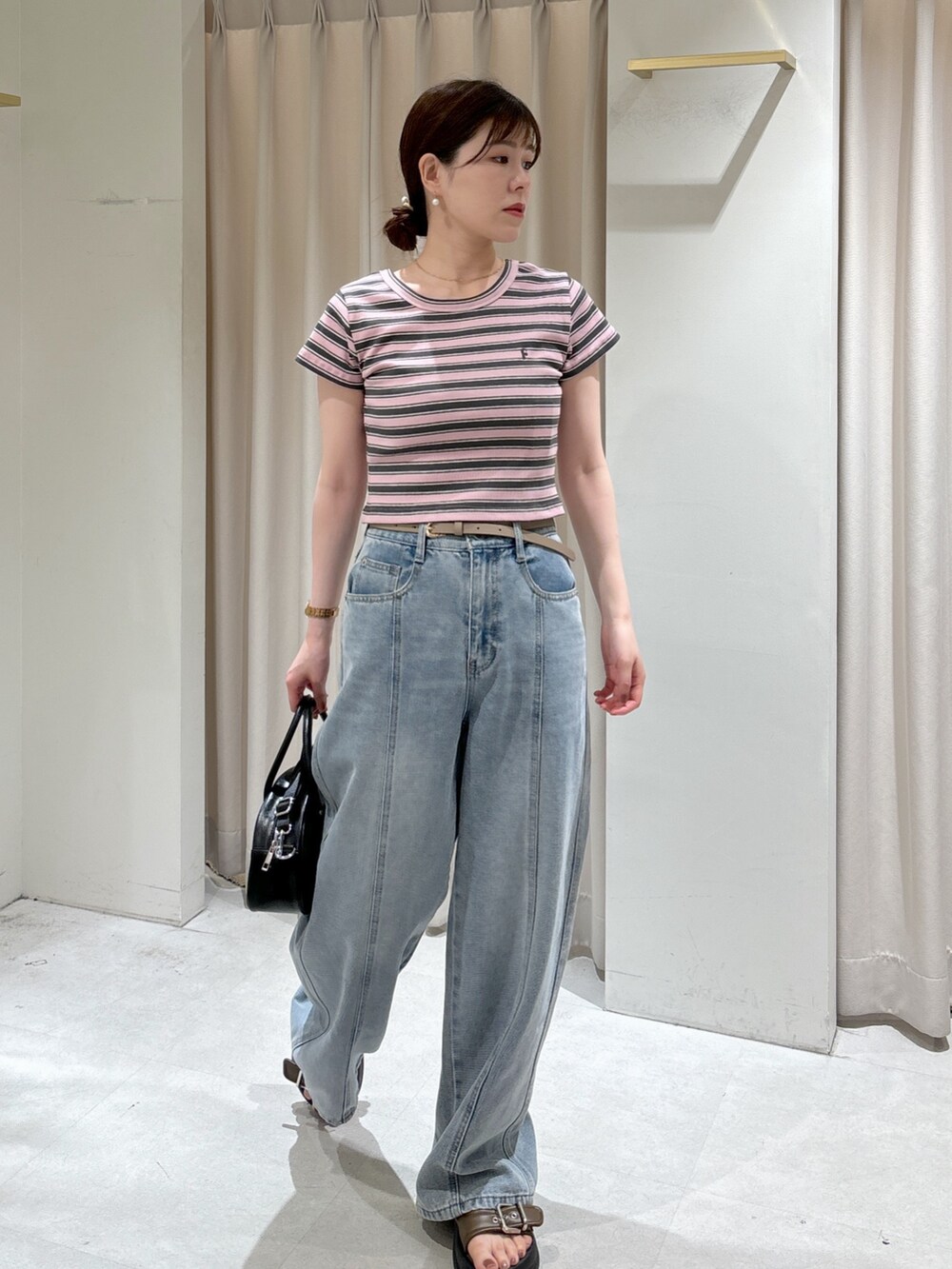 ピンク系のTシャツ/カットソー、ブラック系のトートバッグ、ブルー系のデニムパンツを着用したレディースの夏コーディネートの3枚目の写真