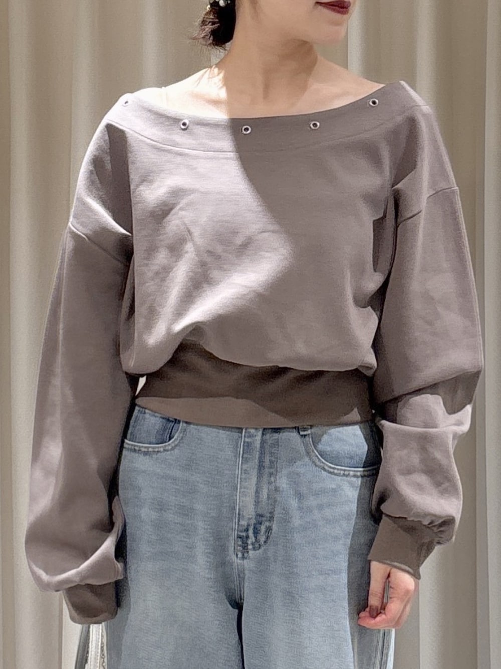 ブラウン系のスウェット、ブルー系のデニムパンツ、シルバー系のショルダーバッグを着用したレディースの冬コーディネートの3枚目の写真