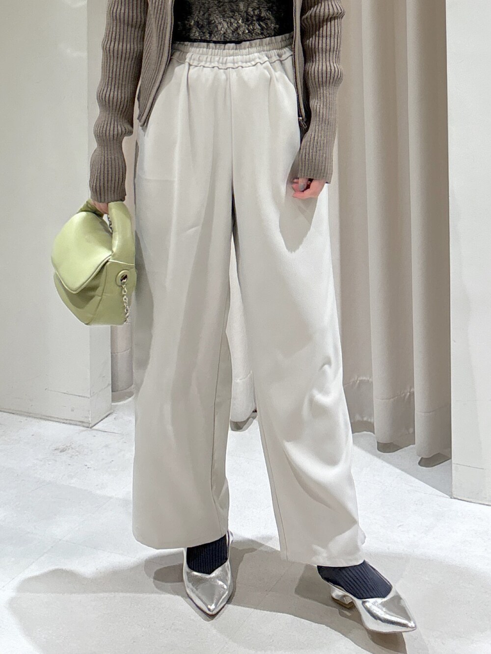 グリーン系のニット/セーター、ブラック系のTシャツ/カットソー、ホワイト系のキャミソールを着用したレディースの冬コーディネートの4枚目の写真