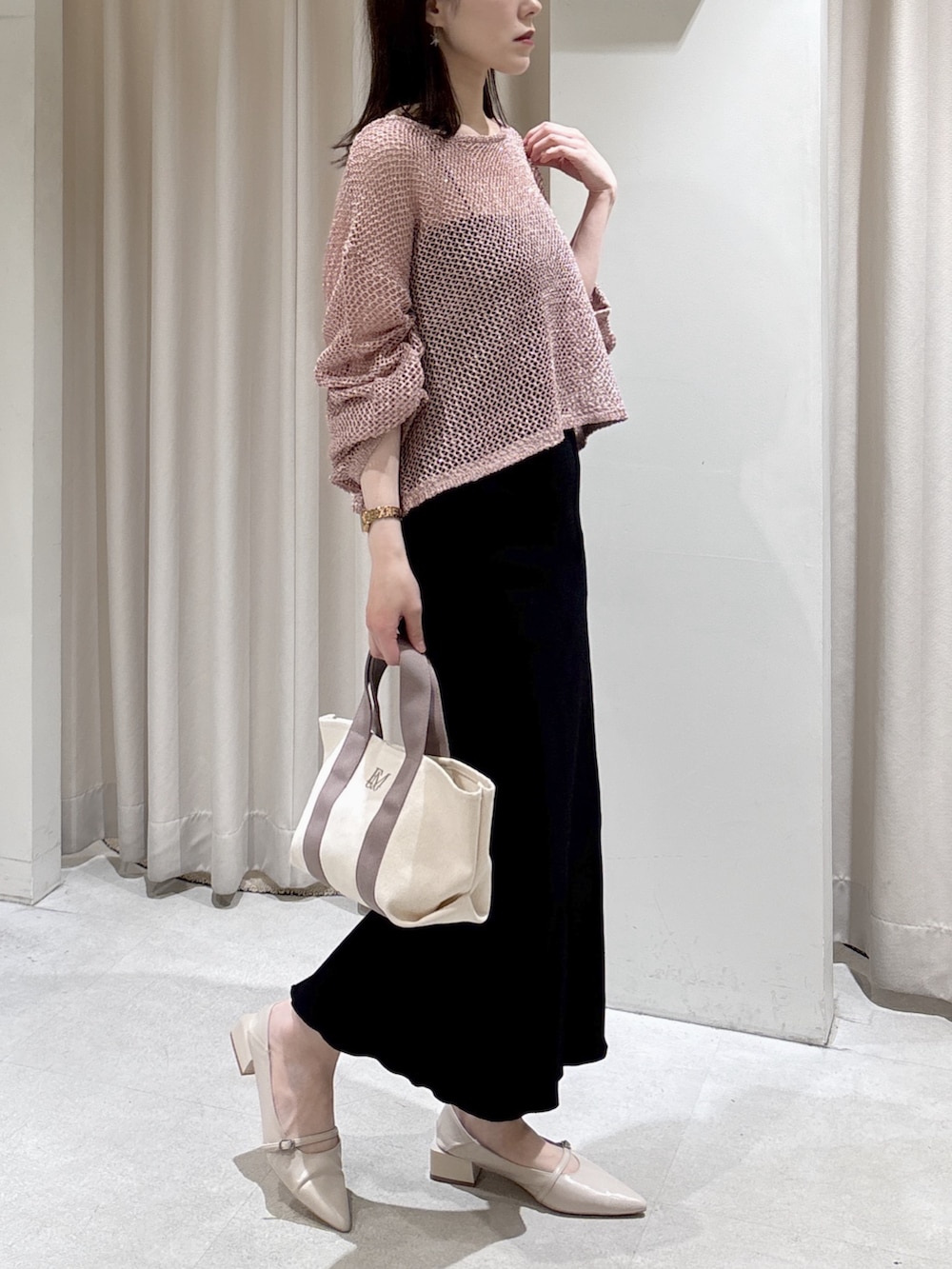 ピンク系のニット/セーター、ブラック系のキャミソール、グレー系のトートバッグを着用したレディースの春コーディネートの3枚目の写真