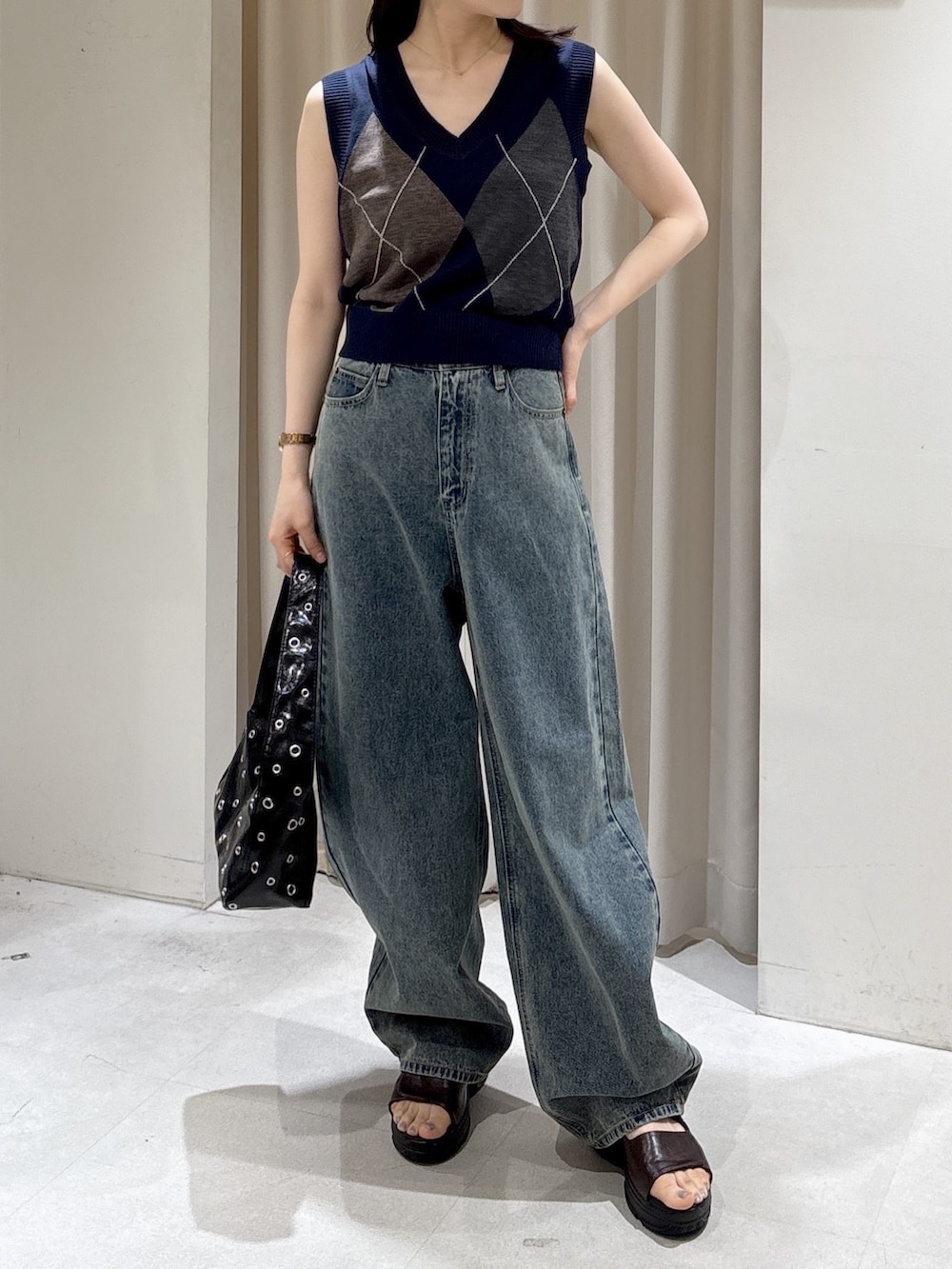 ブルー系のニット/セーター、ブルー系のデニムパンツ、ブラック系のショルダーバッグを着用したレディースの夏コーディネートの2枚目の写真