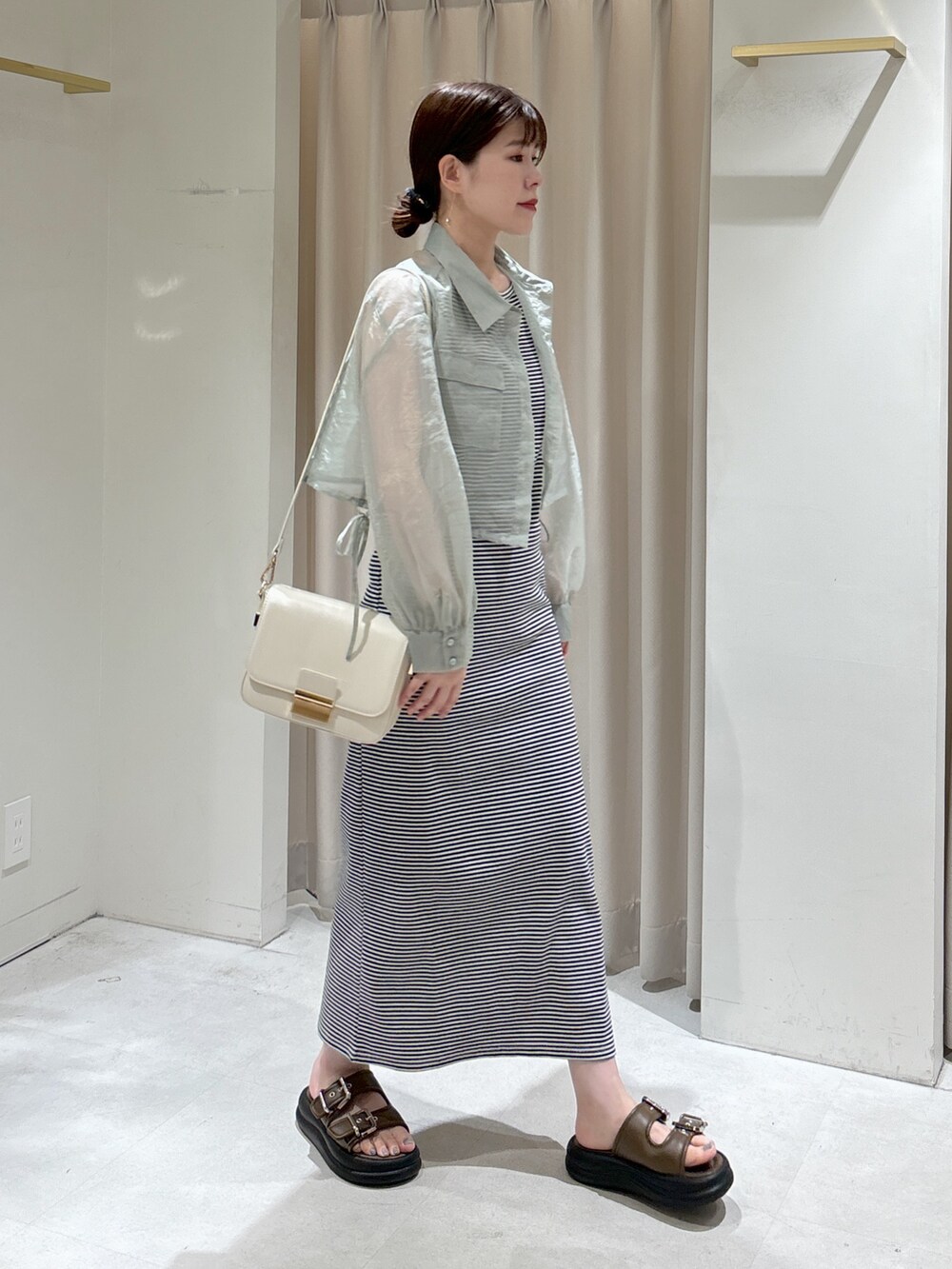 ブルー系のその他トップス、ブルー系のワンピース、ブラック系のトートバッグを着用したレディースの春コーディネートの8枚目の写真