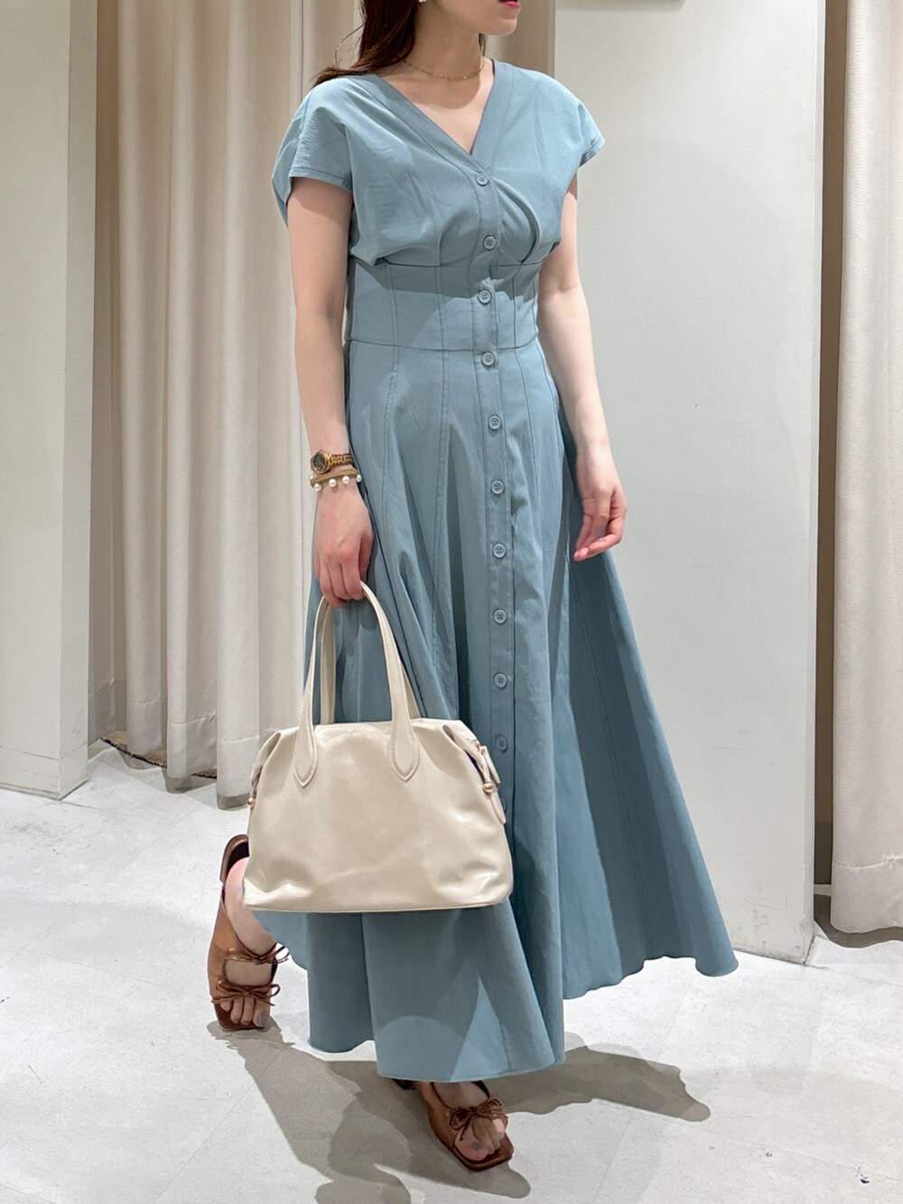 ブルー系のワンピース、ホワイト系のボストンバッグ、ブラウン系のサンダルを着用したレディースの夏コーディネートの7枚目の写真