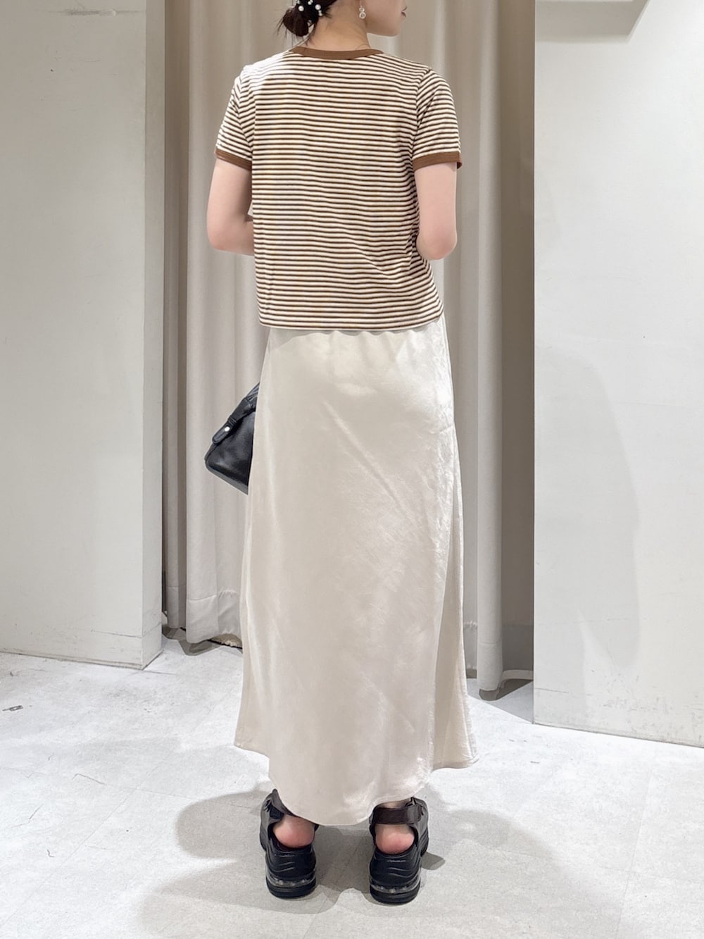 ブラウン系のTシャツ/カットソー、ブラック系のショルダーバッグ、ブラウン系のサンダルを着用したレディースの夏コーディネートの3枚目の写真