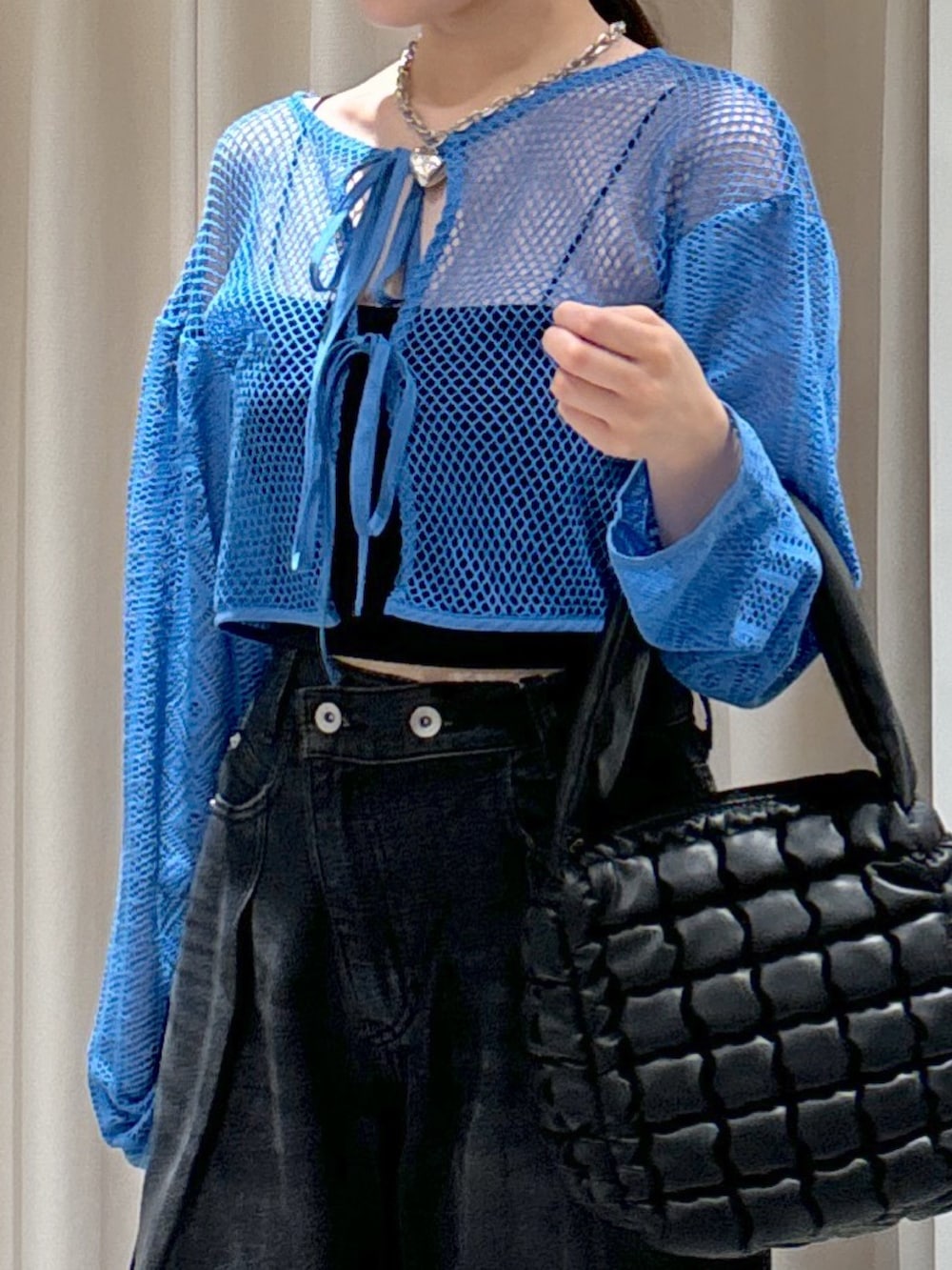 ブルー系のカーディガン/ボレロ、ブラック系のキャミソール、ブラック系のハンドバッグを着用したレディースの夏コーディネートの4枚目の写真