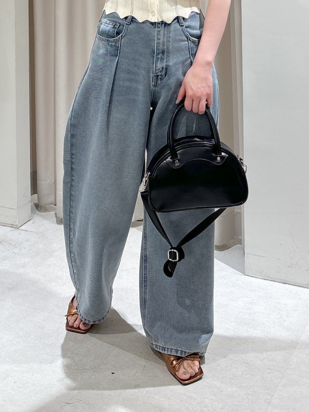 ブラック系のシャツ/ブラウス、ホワイト系のニット/セーター、ベージュ系のトートバッグを着用したレディースの春コーディネートの9枚目の写真